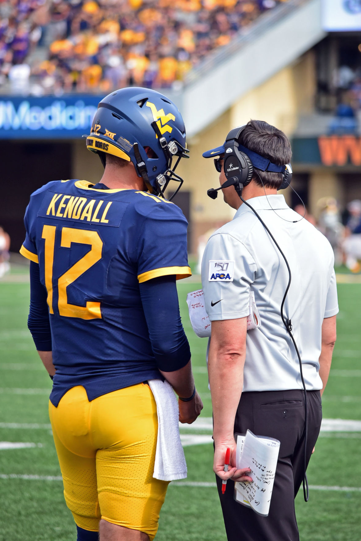 Quarterback Austin Kendall meets on the sideline with head coach Neal Brown to discuss the next play against JMU.
